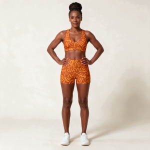 Woman wearing the Orange Swirl Print Sports Bra & Shorts Set by Creamy Cougar